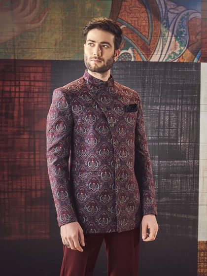 This Jodhpuri jacket in a deep maroon features an elegant, swirling paisley pattern. It's a rich and sophisticated choice for an evening reception or formal dinner.