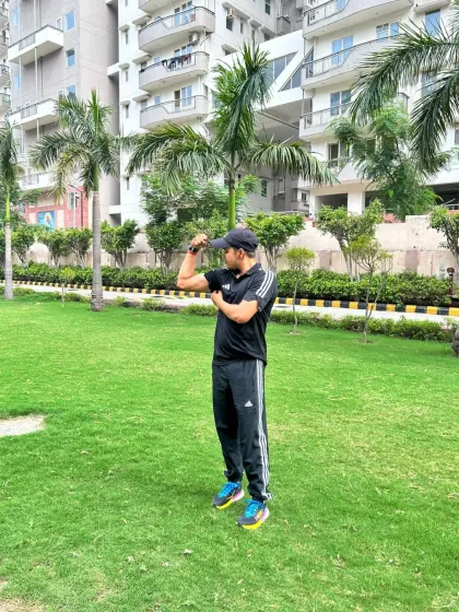 Flexing outdoors, showing that fitness is not confined to the gym.