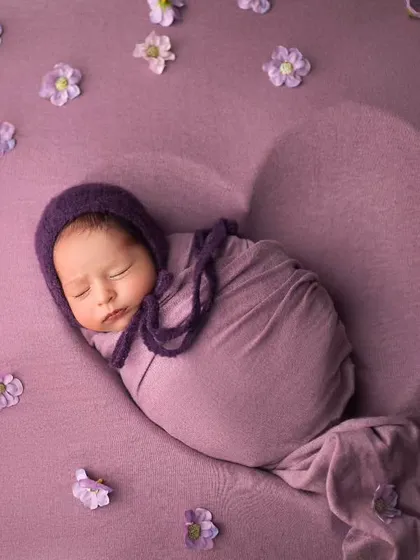 A heart full of love. This overhead shot uses a heart-shaped prop and scattered petals to create a beautiful, artistic composition in lovely shades of purple.