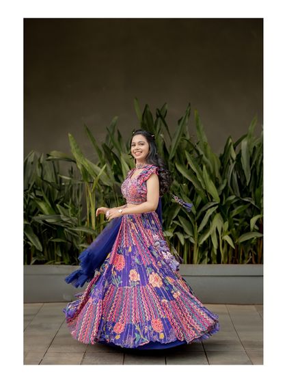 A full-length view of the bride's happy twirl. This shot showcases the beautiful movement and detail of her entire outfit, creating a dynamic and joyful portrait.