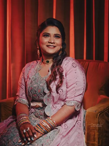A formal portrait of the bride at her engagement. The warm lighting and comfortable seating create a relaxed yet elegant photograph that showcases her complete look.