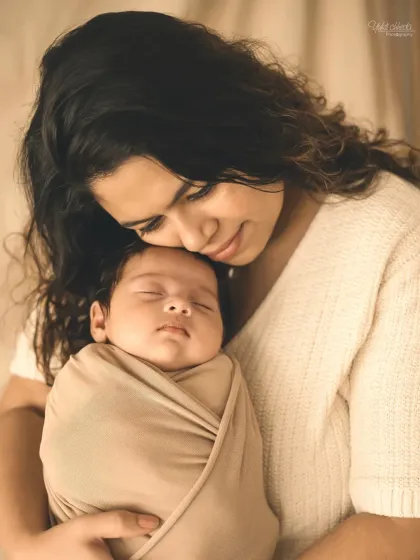 A close-up of a mother and her sleeping baby, a quiet moment filled with love.