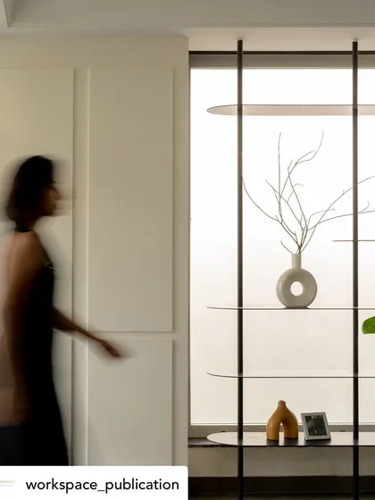 A person's movement captured with a slow shutter speed adds an artistic, ethereal quality to the otherwise minimalist and structured office corridor.