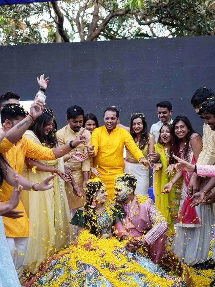 Sharing the joy of Haldi with petals and love. A beautiful, candid moment of the couple being showered with flowers by their friends.