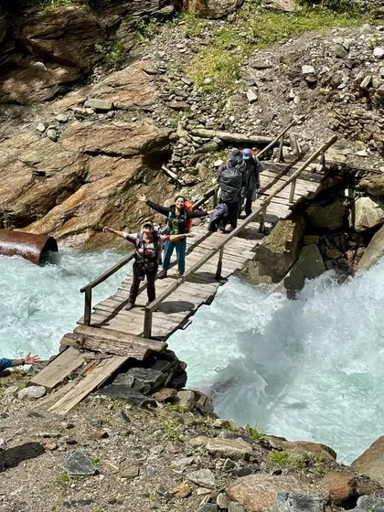 The thrill of crossing a gushing river on a rickety wooden bridge on the Buran Ghati trek. Every moment is an adventure.