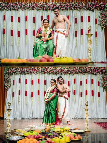 The expecting couple posing on stage during their baby shower, surrounded by traditional fruit platters and floral decorations.