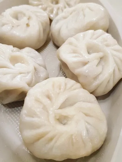 A plate of freshly steamed momos, a favorite snack for all ages. I can serve these with a spicy dipping sauce as part of your appetizer menu.