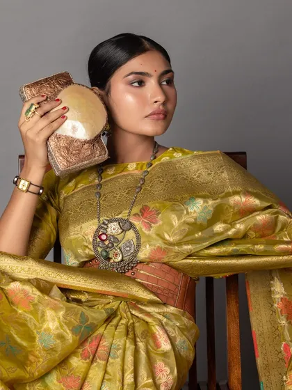 A close-up on the accessories, showing how the texture of the bag and the intricate details of the necklace work with the saree's woven pattern.
