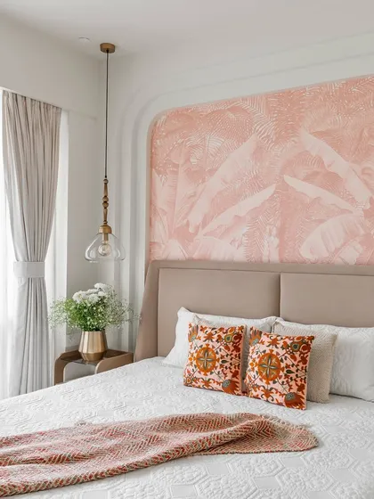 After: The completed bedroom, now a serene retreat with soft pink wallpaper, a custom-arched wall feature, and stylish pendant lights.