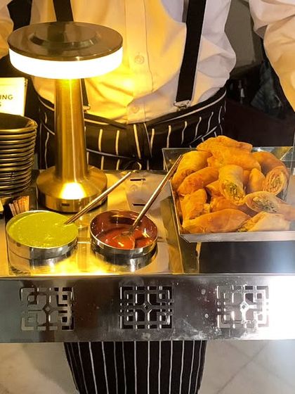 A tray of hot and crispy veg spring rolls, served with mint and sweet chili sauces.