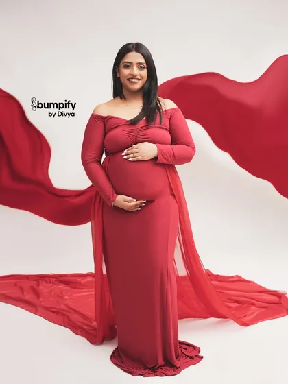 A classic and powerful portrait in red. We used a flowing red fabric to create a dramatic, wing-like effect behind the mom-to-be, making for a truly stunning image.