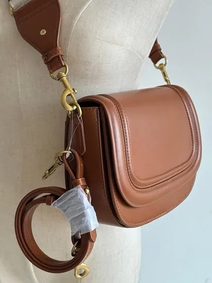 This shot shows the Noble bag with both straps attached, giving you an idea of how you can switch up your look. The long leather strap is still wrapped for protection.