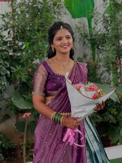 Another shot of the bride's welcome look, holding a bouquet of flowers.