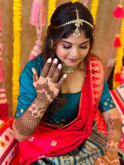 A close-up of the client's beautiful smile and her equally beautiful mehndi, a perfect combination for any celebration.