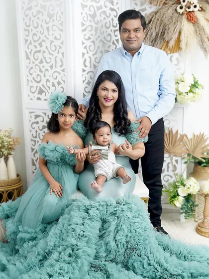 A family of four dressed in serene sea-green. The mother's incredible ruffled gown makes a stunning statement in this elegant family portrait.