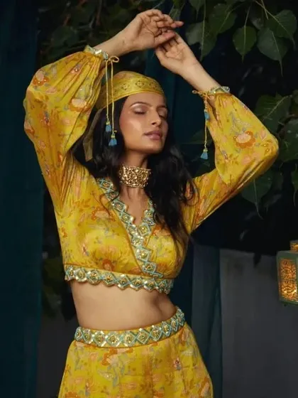 A beautiful, expressive pose from a fashion lookbook. The makeup is warm and sun-kissed, with a focus on glowing skin and softly defined eyes, perfectly suiting the bohemian-inspired yellow outfit.