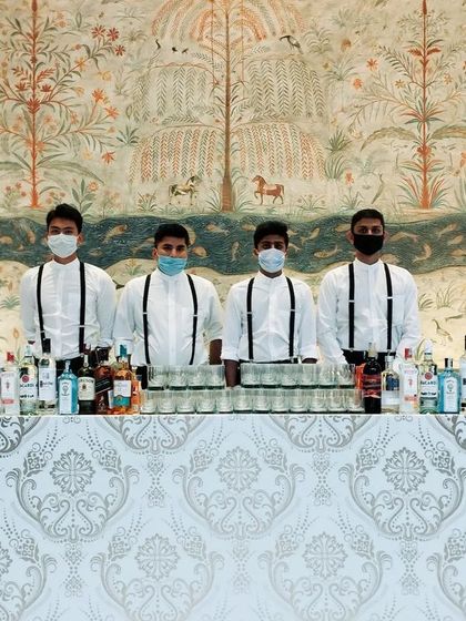 This bar features a beautiful damask pattern front, blending perfectly with the elegant decor of a wedding reception. Our team stands ready and masked, ensuring safe and professional service throughout the event.