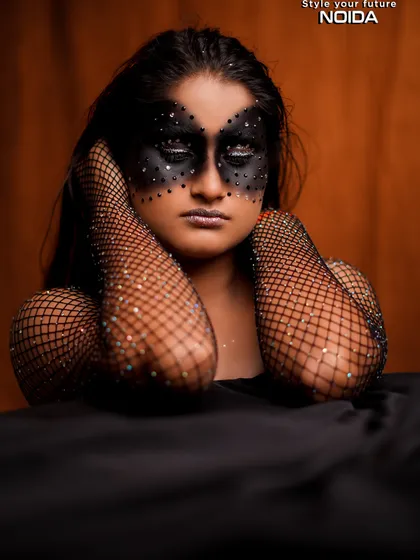A serene pose with the black fantasy mask. The contrast between the dark makeup and the soft pose creates an interesting and artistic dynamic.