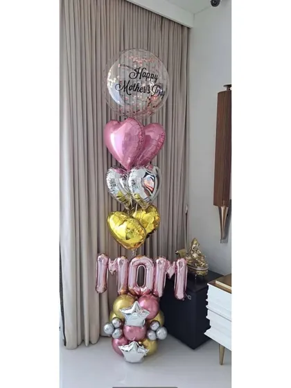 A throwback to a sweet Mother's Day balloon bouquet. We used 'MOM' foil letters and a mix of pink, gold, and silver heart balloons to show all the love.