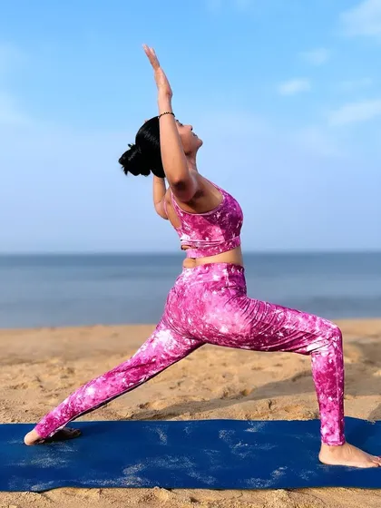 Breathe in the ocean's energy, exhale all the worries. A powerful Warrior I pose on the sand, feeling strong and grounded.