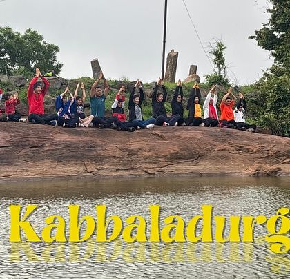 A group practicing some morning yoga by the pond at the base of Kabbaladurga.
