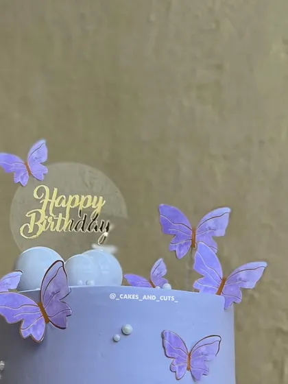 A close-up of the edible butterflies and the acrylic "Happy Birthday" topper.
