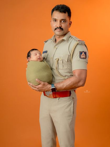 I love incorporating personal elements into my shoots. Here, a proud father in his police uniform holds his safely swaddled newborn, creating a powerful and meaningful portrait.