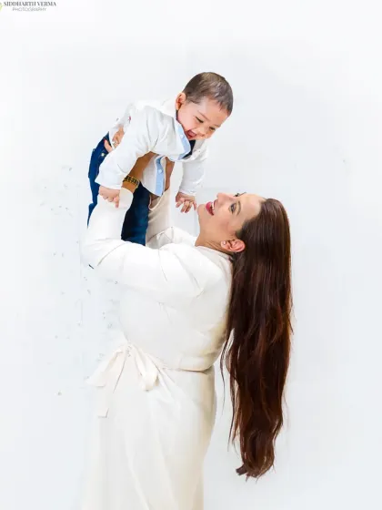 A joyful, candid moment of a mother lifting her baby high. This action shot is full of laughter and captures the playful side of motherhood.