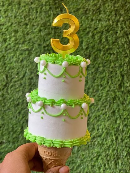 A close-up of the tiny and intricate cone cake, complete with a birthday candle.