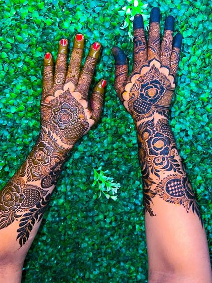 A creative shot of the floral semi-bridal mehendi, showing how the designs flow up the arms.