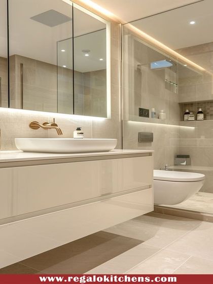 A high-gloss white floating vanity creates a clean and spacious feel in this bathroom. The large, backlit mirror provides excellent lighting for daily routines.