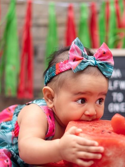 Getting a close-up look at her watermelon "cake". These sensory experiences create the most authentic and adorable expressions during a milestone session.