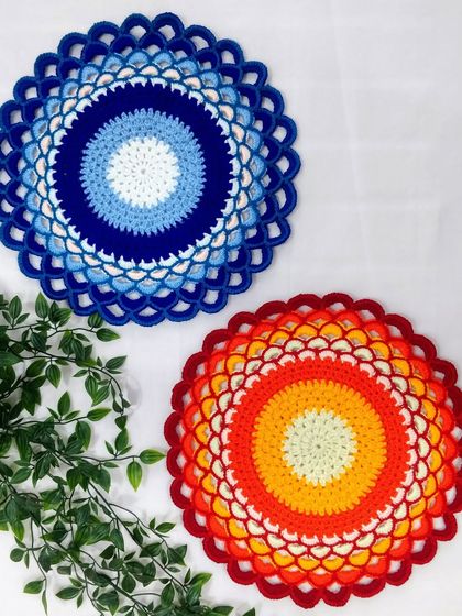 A colorful treat for the eyes. This photo shows two of my doilies, one inspired by the evil eye pattern and the other a fiery sunset gradient.