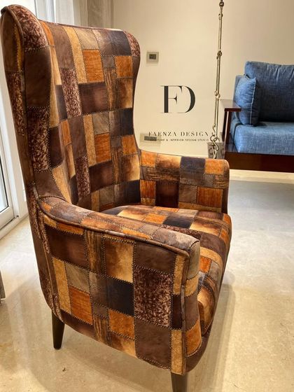A unique high-back armchair upholstered in a patchwork of different brown and tan fabrics. This piece is a testament to our ability to create truly one-of-a-kind, custom furniture.