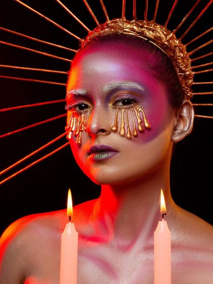 A conceptual portrait titled 'Burning Candles'. This look uses dripping gold makeup effects and creative lighting to create a surreal and artistic image, a style we love to explore in our studio.