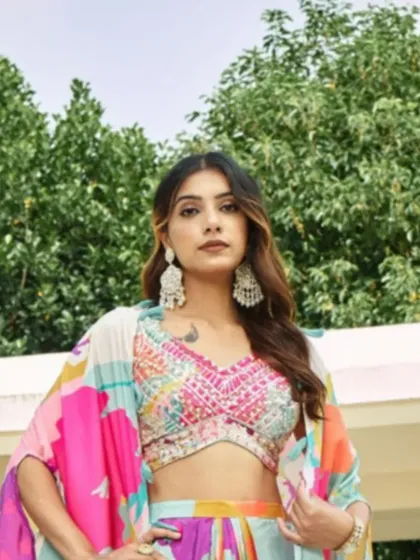 A close-up on the intricately beaded and embroidered blouse, which adds a touch of sparkle to the colorful printed ensemble.