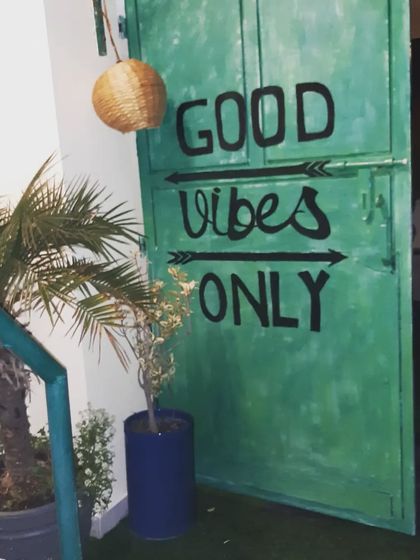 A fun and welcoming touch. We painted this door with a 'Good Vibes Only' message to set the tone for the outdoor space.
