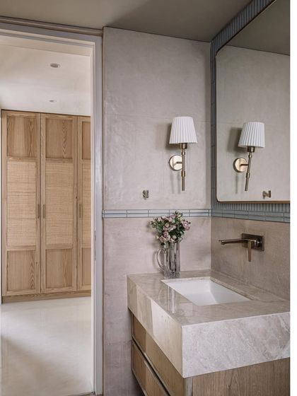 The guest room bathroom continues the cottage-living theme with a mix of marble, wood, and classic fixtures.