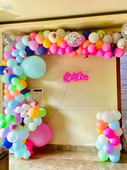 Personalization is key to making an event special. For this party, I arranged for a custom neon sign with the name 'Grisha' and designed a vibrant, multi-colored balloon garland to frame it, creating a unique and personal touch for the celebration.