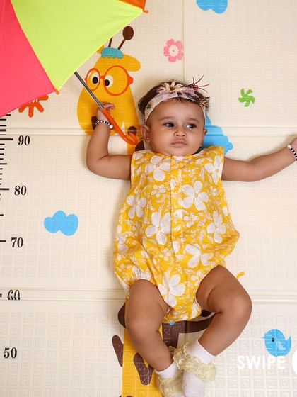 This little one is ready for a rainy day in our yellow floral romper. The playful setup shows how our clothes are perfect for imaginative play.