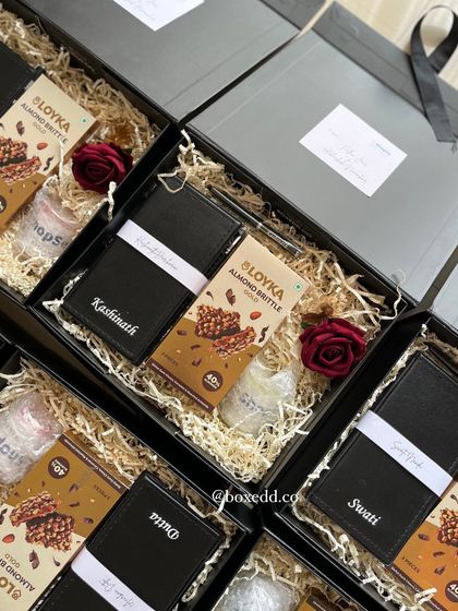 Classic client gifts curated for ShopSe. These elegant black boxes include a personalized notebook, premium almond brittle, and a decorative rose, fostering strong connections through thoughtful gestures.