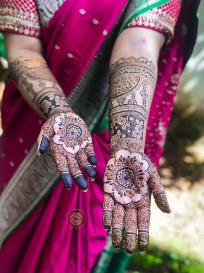Another view of the lovely bride Shahana's henna. The design features a prominent mandala on the palm and a mix of negative space florals and traditional paisleys on the arm.