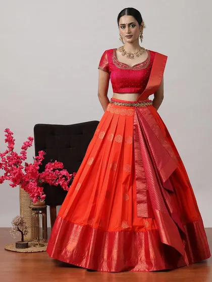 A bright orange-red lehenga with a matching blouse and Banarasi dupatta, perfect for making a bold statement.