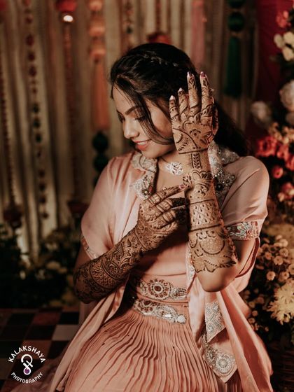 A beautiful shot of the bride admiring her intricate Mehendi design.