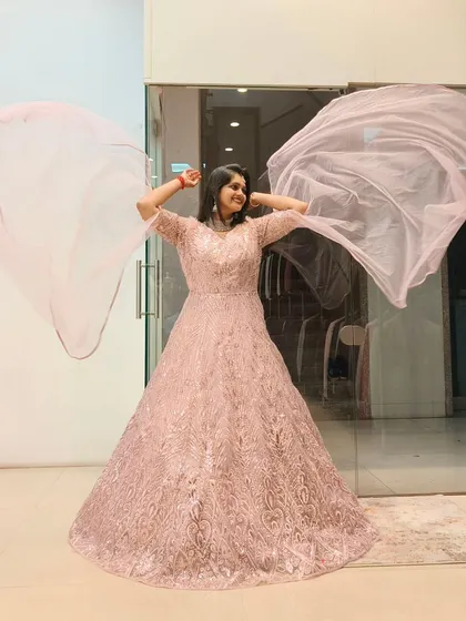 Feel like you're floating in a dream with this ethereal pink gown. The delicate embroidery and flowing fabric are perfect for a reception or engagement, ensuring you sparkle with every step and twirl.