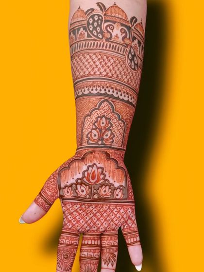 A close-up of a forearm band featuring peacocks and palace architecture. This shows the fine detail I put into every part of the design.