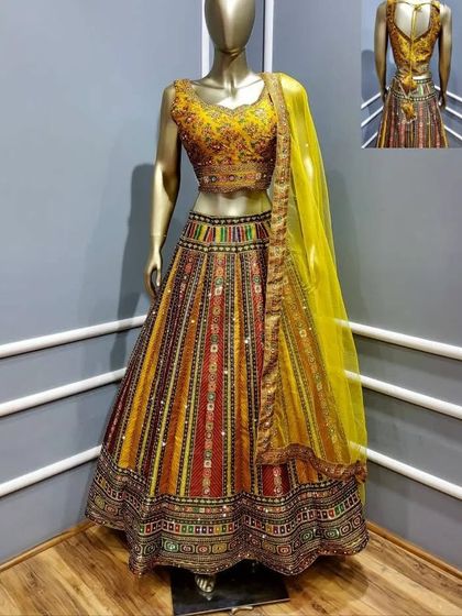A vibrant multi-color lehenga with a yellow blouse and dupatta. The intricate patterns and mirror work make this a festive and eye-catching choice for any pre-wedding celebration.