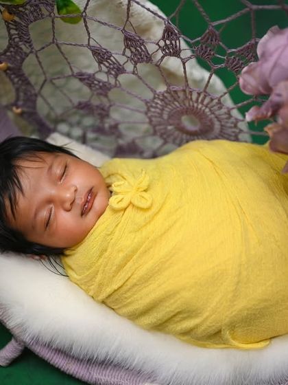 A duplicate of image 257, a lovely shot of a newborn in a dreamcatcher swing.
