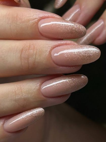 A subtle yet stunning glitter manicure. This design features a sheer nude base with a delicate dusting of fine silver glitter for a sophisticated sparkle.