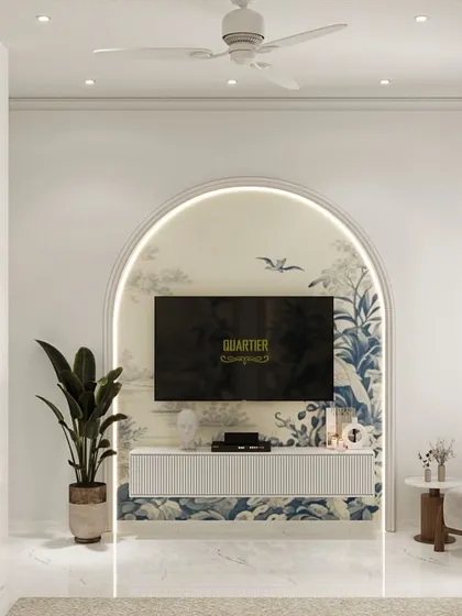 This guest bedroom design for ATS Rhapsody features an arched niche behind the TV, continuing the Chinoiserie theme from the wallpaper. The design is light, airy, and elegant, perfect for welcoming visitors.